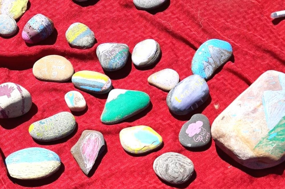 painted rocks and world flags for sale at a lemonade stand